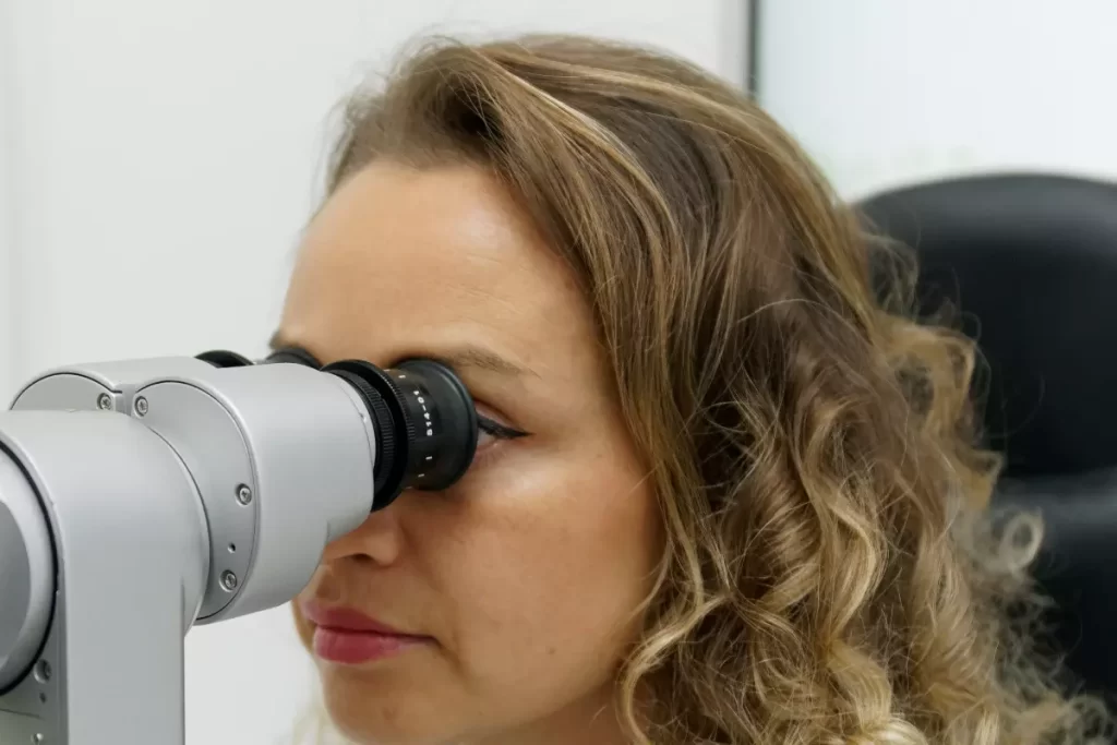 medic oftalmolog efectuind injectii intravitreene la microscop operator